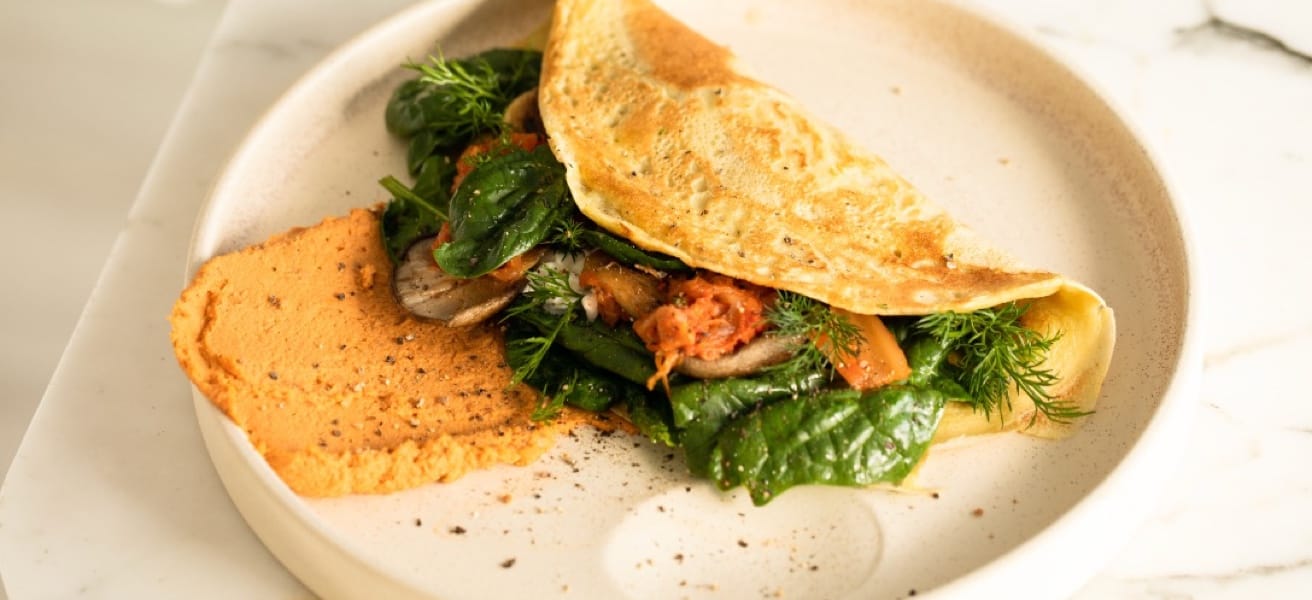 Simple omelette served with greens on a plate